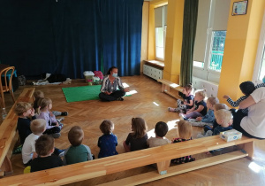 Pani Ania siedzi na podłodze razem ze zwierzętami, a dzieci na ławkach słuchają jej.